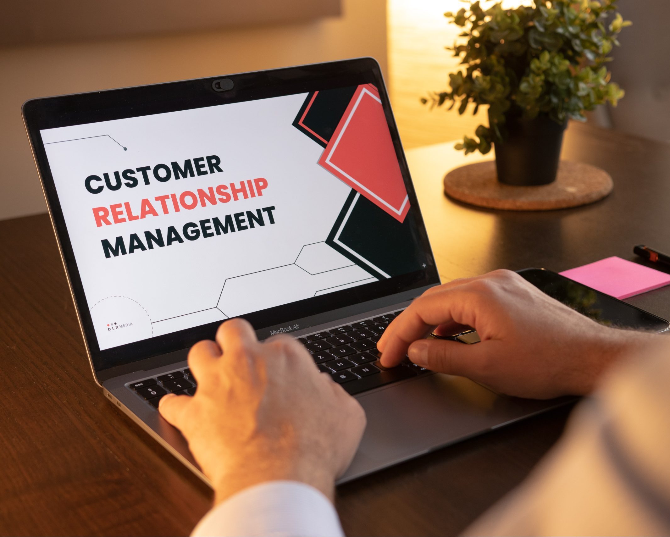 Image of a person with laptop and the screen reads customer relationship management or CRM